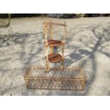 An ironwork three tier plantstand with cherub detail and a further wire basket in the Victorian