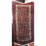 Bokhara type rug with geometric medallion decoration upon a deep red ground 190 x 110 cm