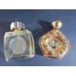 Two Lalique perfume bottles, one decorated with flower head decoration with a central design of