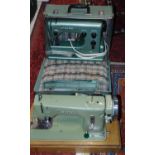 A Husqvarna Viking electric sewing machine in a green colourway with carrying case, together with