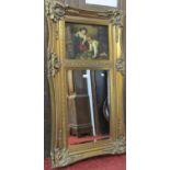 A reproduction wall mirror, the swept stepped and moulded gilt frame with foliate detail,