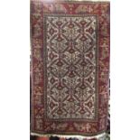 Good quality small Persian rug with geometric floral decoration upon a maroon ground, 135 x 85 cm