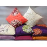 8 contemporary cushions, all with silk covers and feather pads, in shades of purple, cream, orange