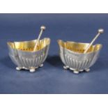 A pair of good quality cast half fluted silver salts with four fluted bun feet and gilt interior,