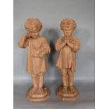 Pair of late 19th/Early 20th century terracotta figures of standing children, one wearing a crucifix
