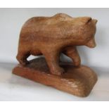 A Black Forest type hardwood carving of a bear upon a naturalistic base, 45cm long x 30cm high