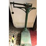 An antique cast iron platform scale, with brass fittings and original green painted and gilt