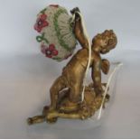 Cast gilt metal figural lamp in the form of a cherub holding a beaded shade decorated with