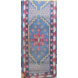 A Chinese full pile runner with red and colourful medallions upon a light blue ground, 320 x 80 cm