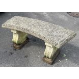 A reclaimed three sectional garden bench with curved slab seat raised on scrolled supports, 117 cm