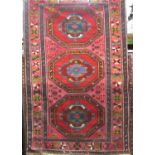 Good Persian three medallion runner/rug with red and blue medallions upon a pink ground, 200 x 130