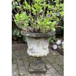 A reclaimed campana shaped garden urn with flared rim and repeating face mask and floral swag