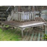 A good quality weathered teak tree bench with slatted seat and back, 230 cm wide x 90 cm high
