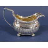 Good quality Georgian silver boat shaped half fluted cream jug with stylised C scroll handle with