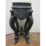 An antique carved Indian torchere stand raised on four shaped supports, bird, animal and floral
