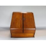 Early 20th century golden oak desk top box, the sloped top enclosing a waterfall interior and
