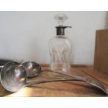 Silver coloured dimpled glass decanter, 24 cm high, together with two silver plated soup ladles (3)