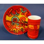 A Poole Pottery charger with red, yellow, orange and green abstract style decoration and with