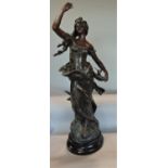 French cast spelter figure of a standing maiden upon a stepped circular ebonised plinth base, 74