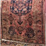 Full pile Persian rug, central blue medallion framed by foliage, washed red ground