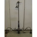 A coated cast metal hanging ceiling light with two scrolling branches, tall knopped stem and three