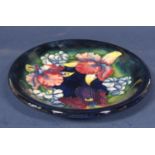 A Moorcroft blue ground dish with iris decoration and with painted signature and impressed marks