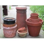 A reclaimed and partially later infilled terracotta cylindrical chimney pot, 58cm high, together