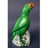 A Chinese model of a green parrot with pierced detail to the beak and to the base, 23.5cm tall