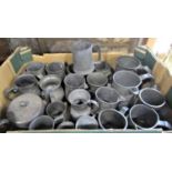 A box containing a large collection of pewter tankards