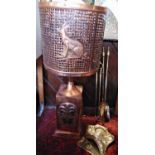An unusual possibly African copper floor lamp, with geometric pierced shade embossed with animals