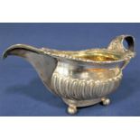 A good quality Georgian cast silver half fluted sauce/cream jug, with cast scallop shell and