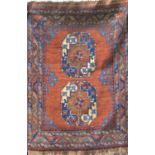 Afghan two medallion rug with blue floral medallions upon a burnt orange/brown ground, 130 x 95 cm