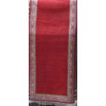 Full pile Persian runner with floral borders and red ground, 290 x 85 cm
