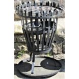 A contemporary brazier type barbecue of circular tapered form with open strapwork framework