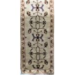A Persian runner with geometric floral decoration upon an ivory ground, 310 x 85 cm