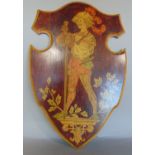 A Sorrento shield shaped wooden panel decorated with a swordsman holding or drinking a glass of