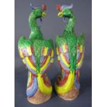A pair of oriental models of green pheasant or phoenix type birds with polychrome painted