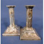 Pair of Adam style silver canon barrel candlesticks, embossed with floral swags and rams heads,