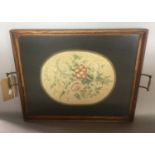 Early 20th century embroidery of floral bouquet bordered by black silk and mounted in a glazed tray,