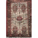 Full pile Afghan rug with various maroon and red shield medallions upon a cream and red ground,