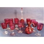 A large collection of cranberry glassware to include a bell, a baluster jug and thirteen various