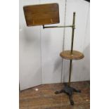 A Victorian reading stand with cast iron base, lions paw feet, the brass column supporting a