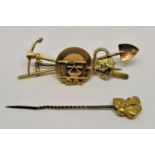 14k gold rush brooch, 6.1cm W approx, 7.8g (possible losses) and a gold nugget stick pin, 4g (2)