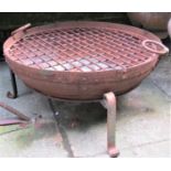A weathered/used ironwork banded fire bowl and stand, with drop ring handles and applied label '