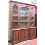 A Victorian mahogany inverted breakfront three door bookcase, the lower section enclosed by four