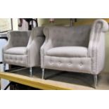 A pair of contemporary tub chairs, the linen covers with studded borders, raised on tapering