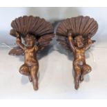 Pair of 19th century carved walnut wall brackets in the form of cherubs supporting scallop shells,