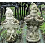 Two similar reclaimed garden gnomes, each carrying coopered planters, 66cm and 48cm in height