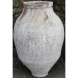 A terracotta oviform jar, with incised comb detail, and white washed/powder finish, 60cm high approx
