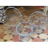 A set of three graduated galvanised wirework baskets with sprung loop handles